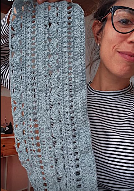 Julieta mostrando una muestra de tejido celeste a medio hacer